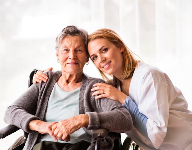 portrait of an elder and a caregiver smiling