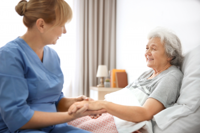 caregiver massaging hand of elder woman